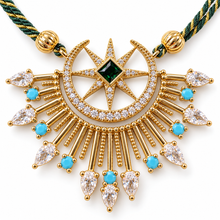 Load image into Gallery viewer, Close-up of Celestia's 45 × 35 mm moon and star pendant with 18K gold plating and green, turquoise-colored and clear cubic zirconia.