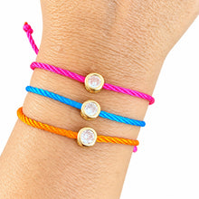 Cargar imagen en el visor de la galería, Marlene pink, blue and orange cord bracelets with round crystal accents on a wrist against white