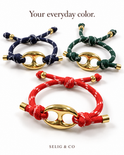 Load image into Gallery viewer, Adjustable rope bracelets in navy, forest green and red with gold-tone oval links
