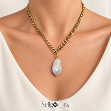 Cargar imagen en el visor de la galería, Collar Luna con perla barroca, mostrado puesto con blusa color marfil.
