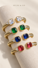 Cargar imagen en el visor de la galería, Four open cuff bracelets in clear, green, blue and raspberry pink on an ivory display
